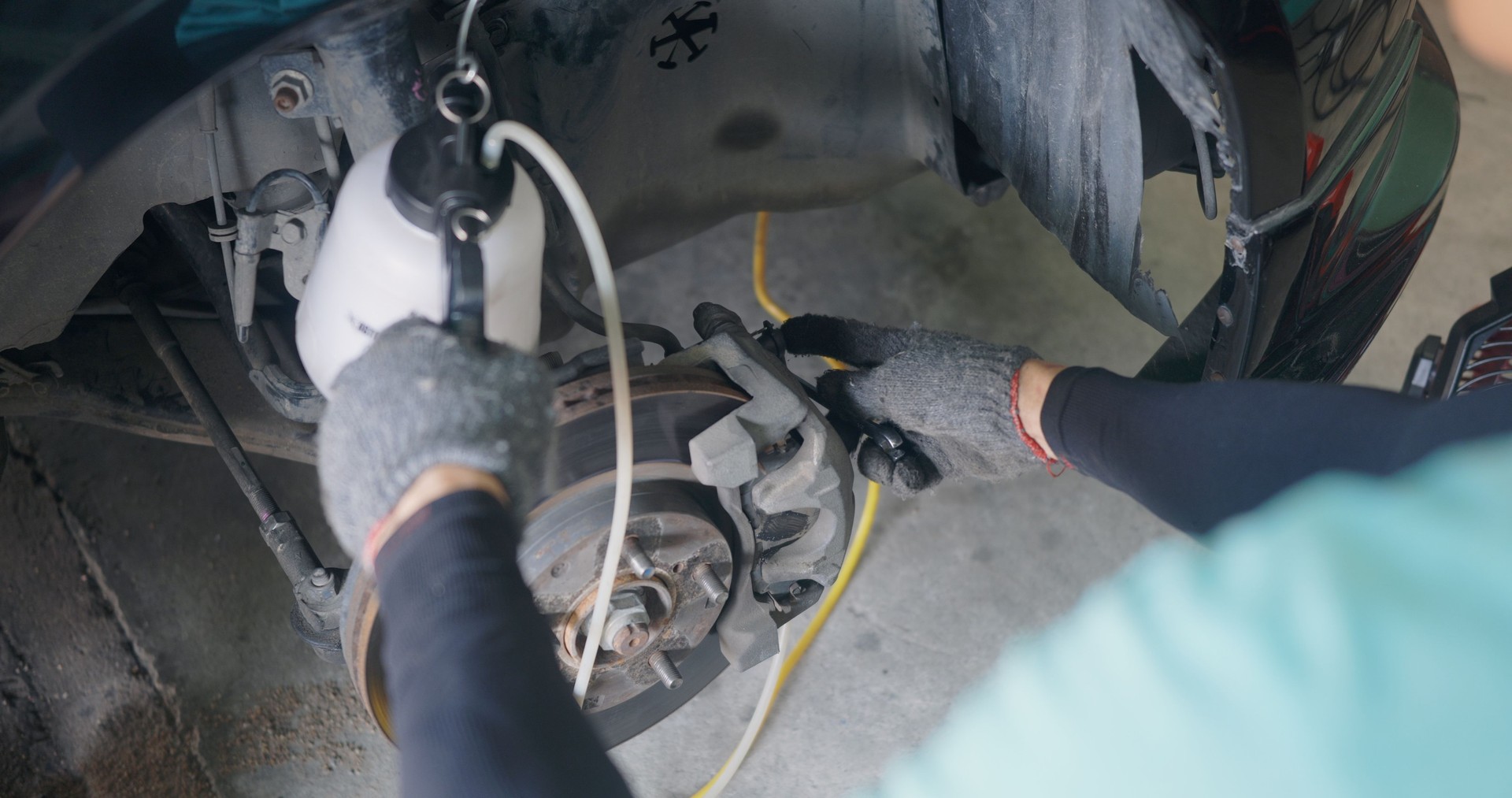 Auto mechanic replacing brake fluid on a vehicle